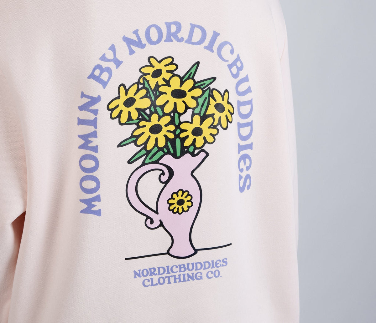 4. Close-up of flower bouquet graphic on back of light pink Moomin hoodie