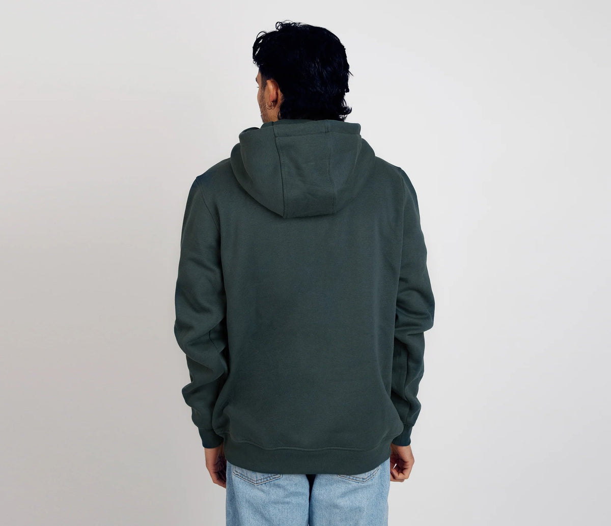 2. Back view of men's dark green Snufkin Fishing Hoodie by Moomin, styled with light denim in studio