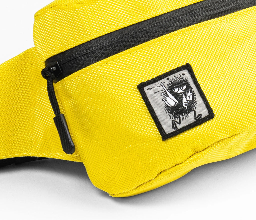 3. Close-up of yellow waist bag featuring Stinky character patch and black zipper detail