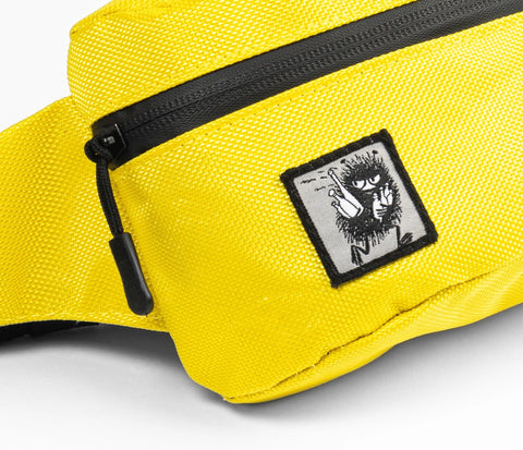 3. Close-up of yellow waist bag featuring Stinky character patch and black zipper detail
