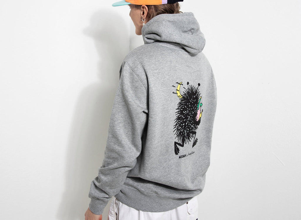 7. Male model wearing grey Moomin hoodie, showing back design in studio