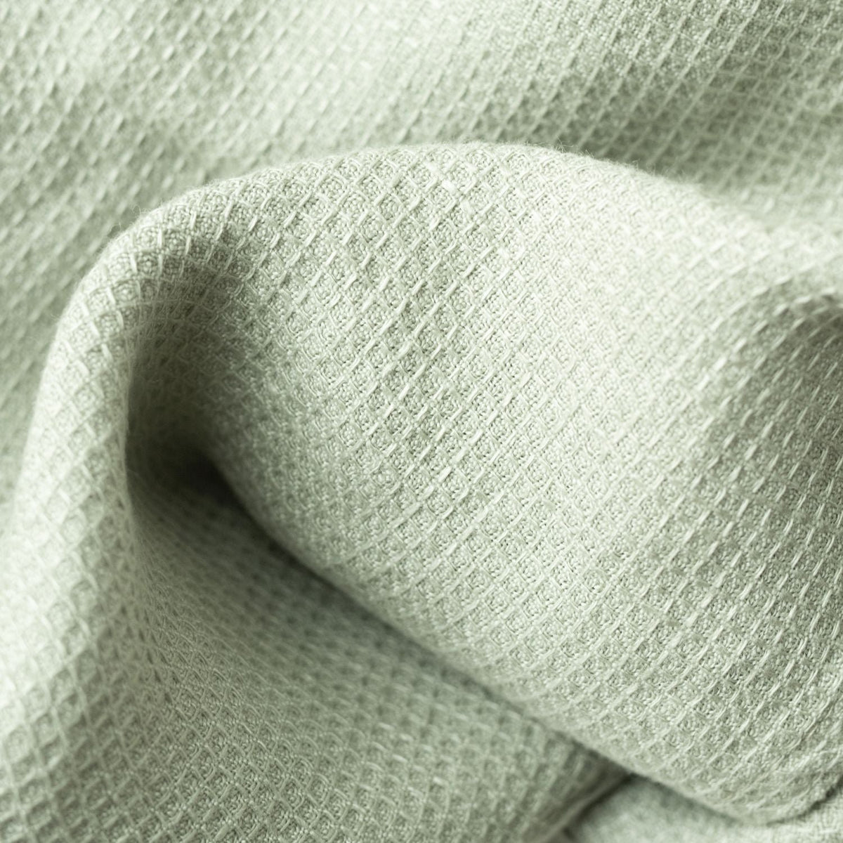 3. Close-up of sage green waffle linen fabric texture showing fine weave
