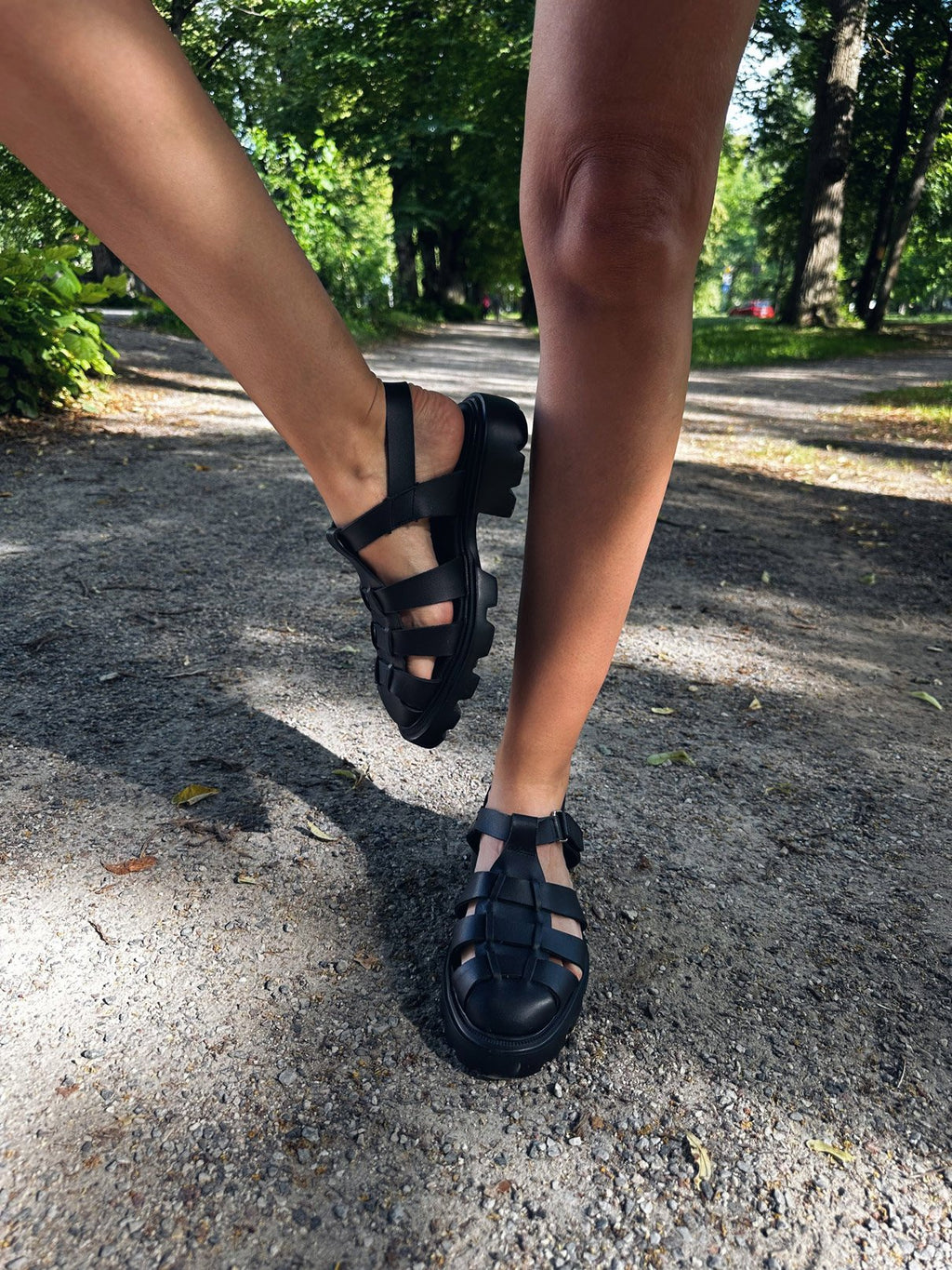 6. Women's black Samelin sandals worn on a gravel path, emphasizing comfort and grip