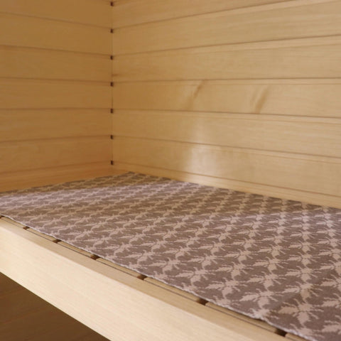 1. Sauna bench seating pad with Hiiumaa fly pattern in beige and brown, placed on wooden sauna bench, made of 52% linen and 48% cotton, by LOKO