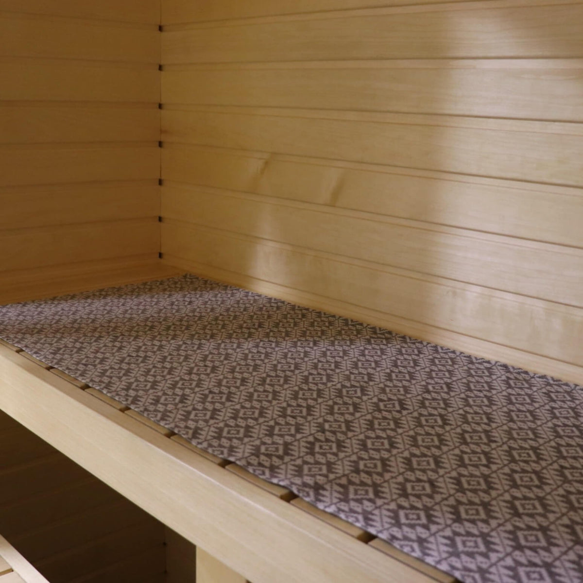 1. Sauna bench with LOKO seating pad featuring Harju County mitten pattern in linen-cotton blend