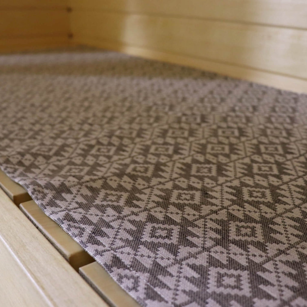2. Close-up of LOKO sauna seating pad showing traditional Harju County mitten pattern on linen-cotton fabric