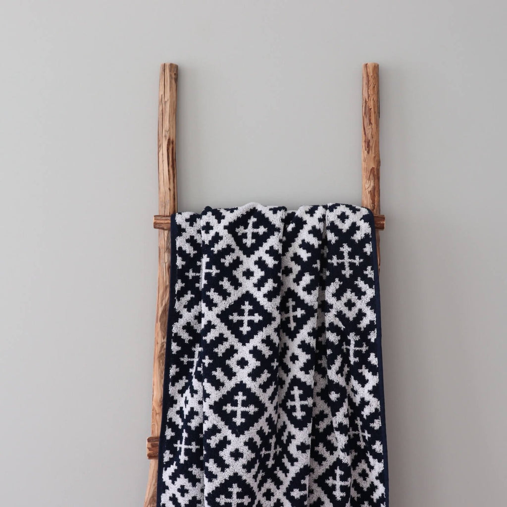 2. Close-up of black and white sauna towel featuring Setumaa mitten pattern on wooden ladder