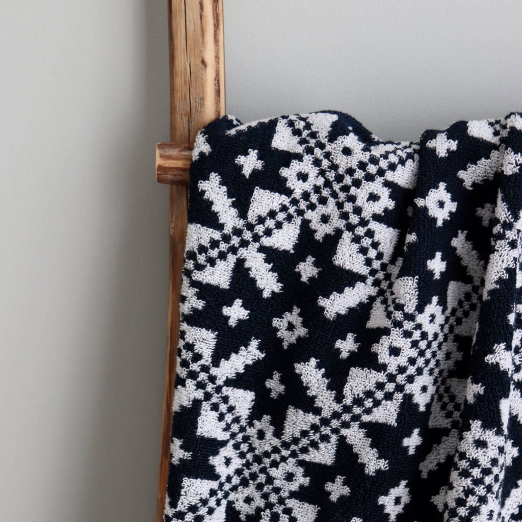 3. Close-up of navy sauna towel with white Pärnumaa mitten pattern on wooden ladder