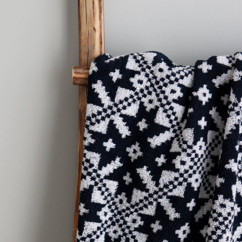 3. Close-up of navy sauna towel with white Pärnumaa mitten pattern on wooden ladder