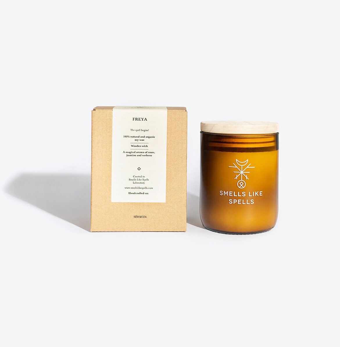 3. Smells Like Spells FREYA candle in amber glass jar with packaging, studio setting