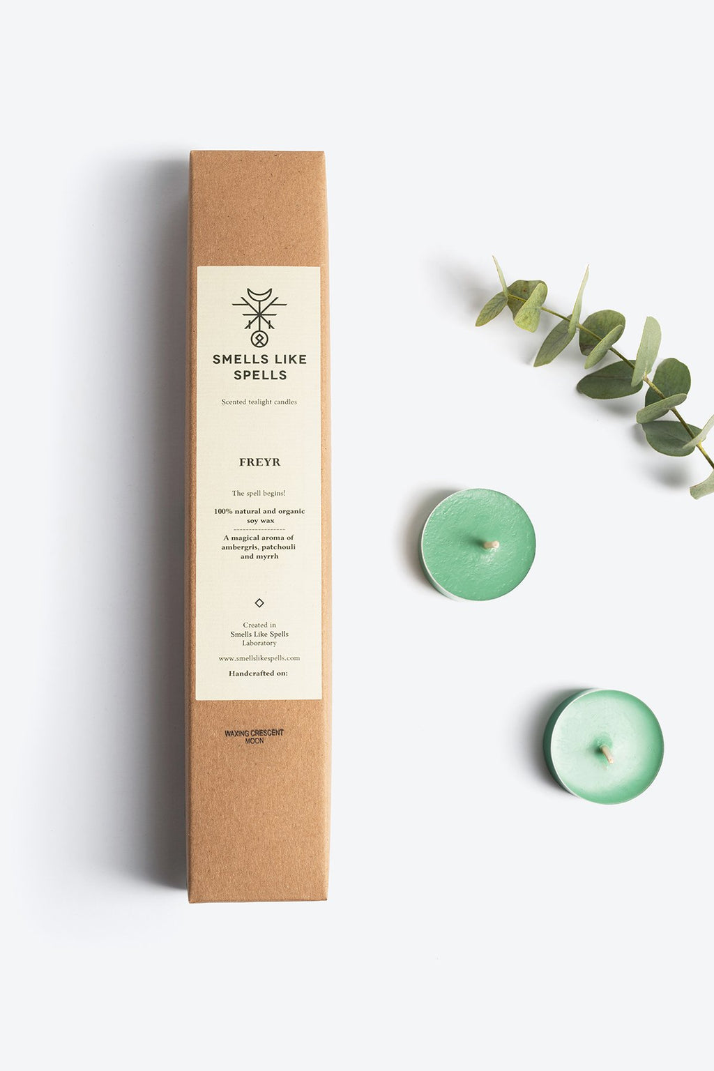 2. Smells Like Spells Scented Tealight Candles FREYR with two green candles and eucalyptus leaves, highlighting natural ingredients