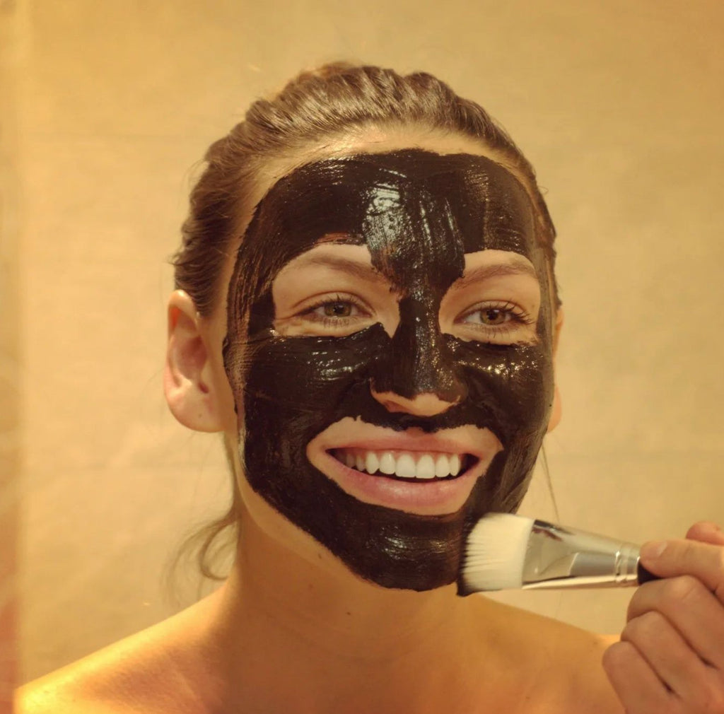 1. Woman applying Turbliss Bioactive Peat Mask for Sensitive Skin with brush, showcasing natural skincare routine
