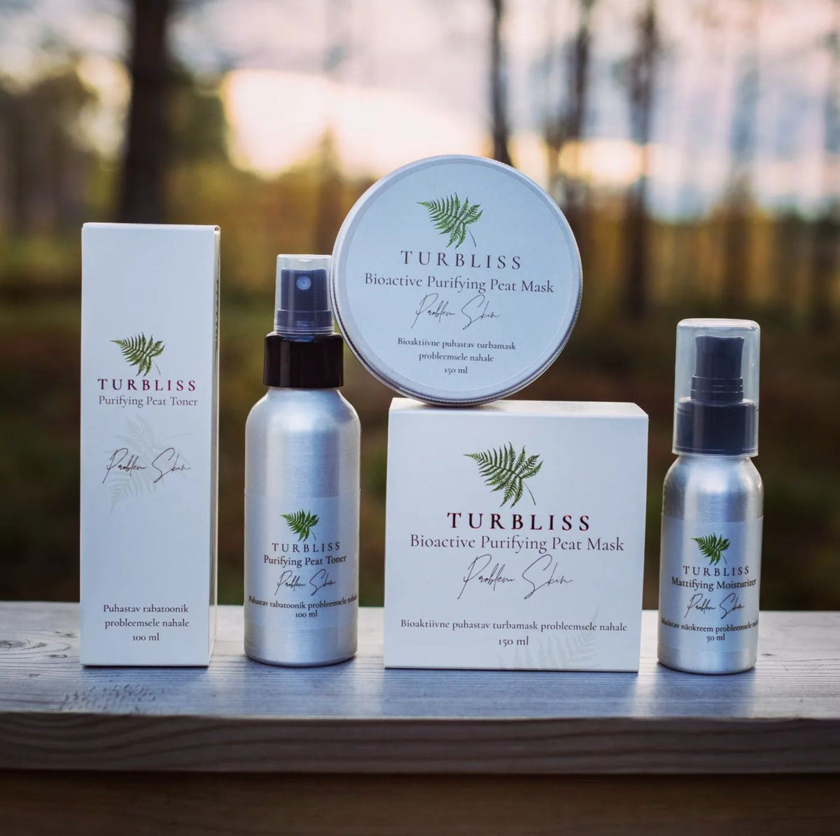 2. Turbliss skincare collection featuring Bioactive Bog Tonic, Purifying Peat Mask, and Moisturizing Mist on a wooden surface outdoors