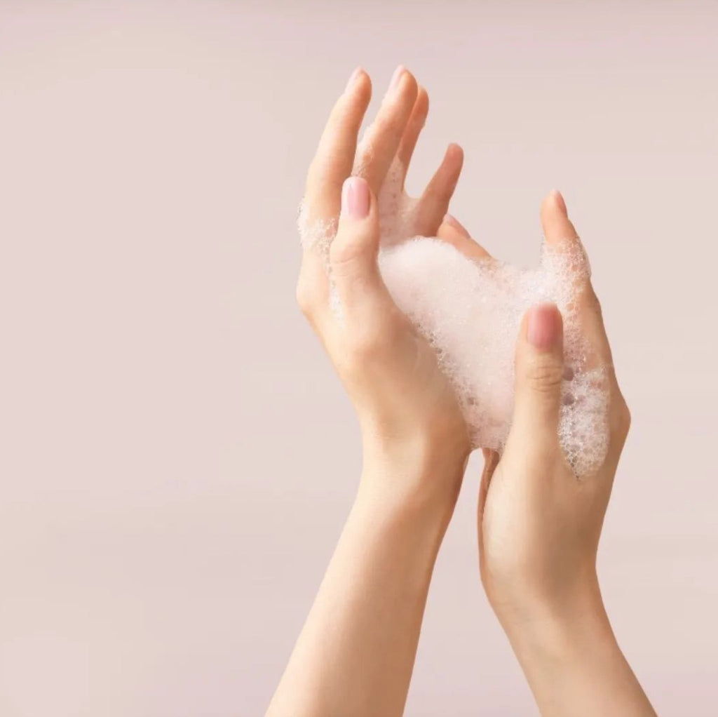 3. Hands holding Berrichi Facial Cleansing Foam, showcasing foamy texture