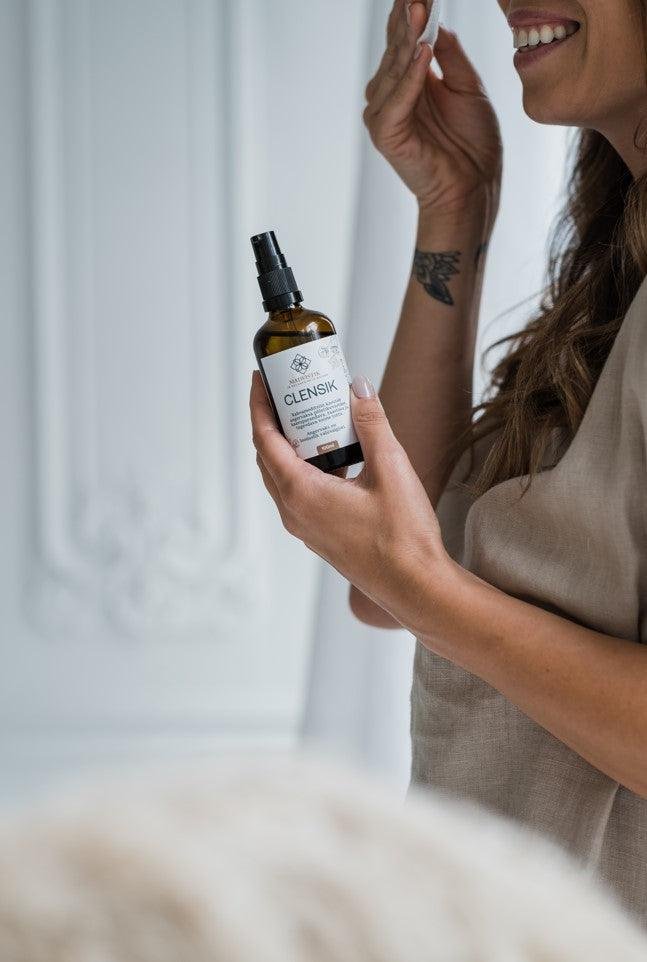 1. Woman applying MaiWistik CLENSIK Make-up Removal Oil with local herbs, shown in lifestyle setting