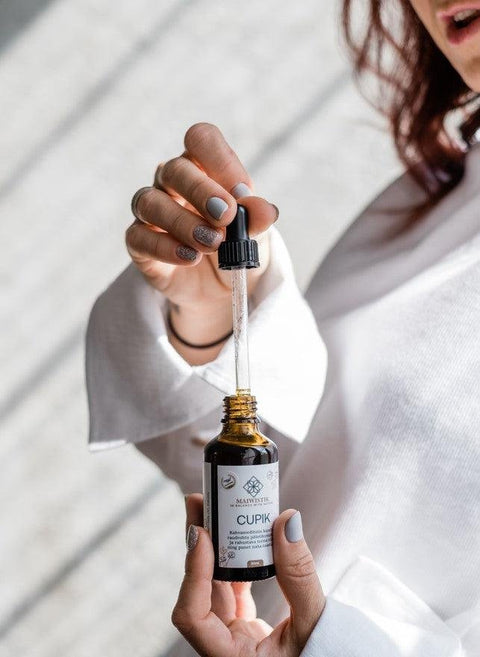 2. Close-up of CUPIK Oregano and Yarrow SOS Oil bottle with dropper, highlighting product details and award badge