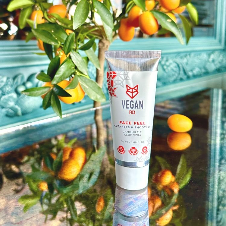 3. Vegan Fox Face Peel displayed on a reflective surface with orange fruits, highlighting its natural ingredients
