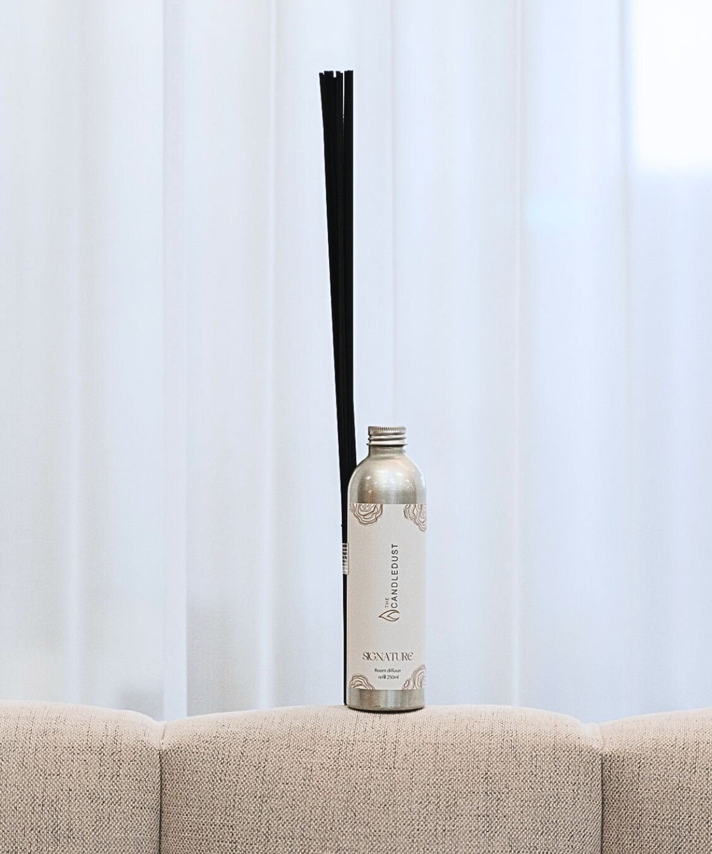 3. Candledust luxurious room diffuser refill with black sticks on a beige sofa