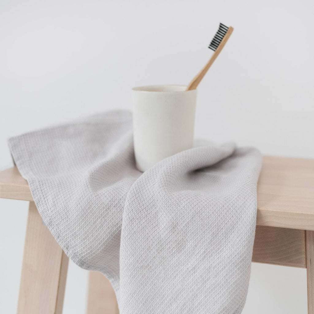 2. Silver linen fine waffle towel draped over wooden stool with toothbrush in cup, simple bathroom decor