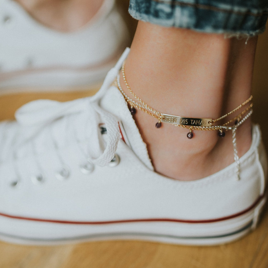 1. Lifestyle image of New Vintage by Kriss Anklet Eat, Pray, Love worn by a woman with white sneakers