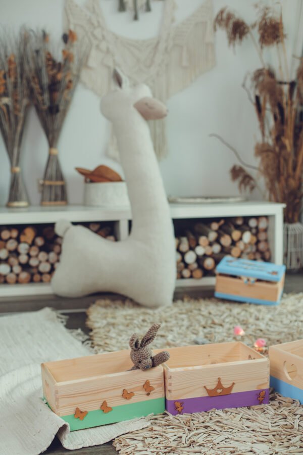 2. Beige giant plush alpaca toy in children's room with wooden boxes and decor