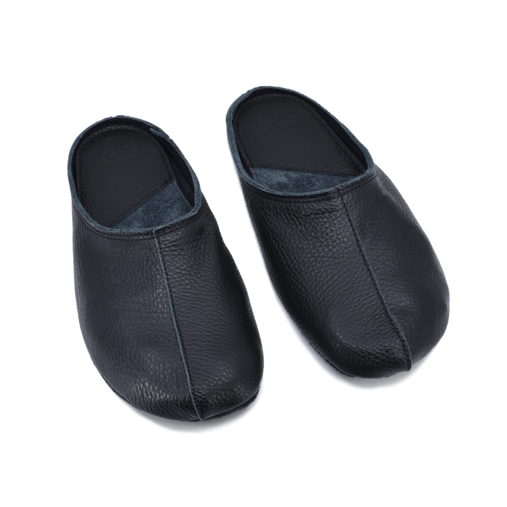 2. Pair of Omaking Sulbi black leather slippers displayed from above, showcasing classic design and natural feel