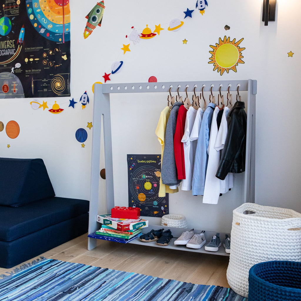 6. Grey toddler clothing rack with colorful clothes and shoes in a space-themed children's room