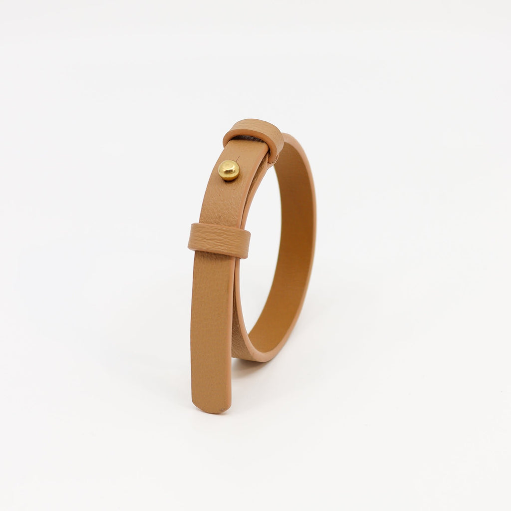 2. Studio image of Tairi Roosve leather bracelet in desert tan with brass fastener, highlighting double-layered design