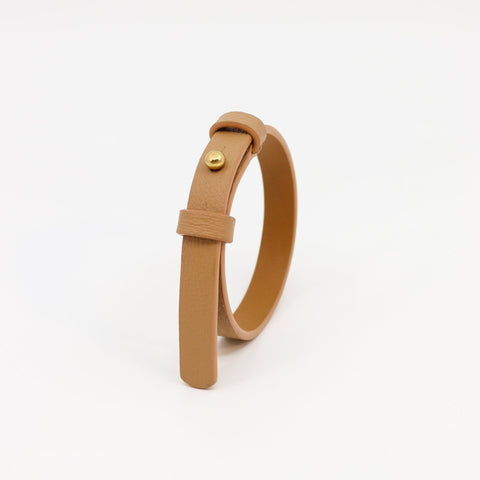 2. Studio image of Tairi Roosve leather bracelet in desert tan with brass fastener, highlighting double-layered design
