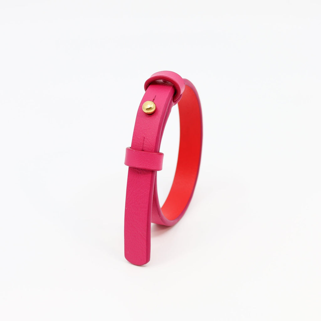 2. Studio shot of Tairi Roosve fuchsia leather bracelet with brass fastener, showing adjustable holes
