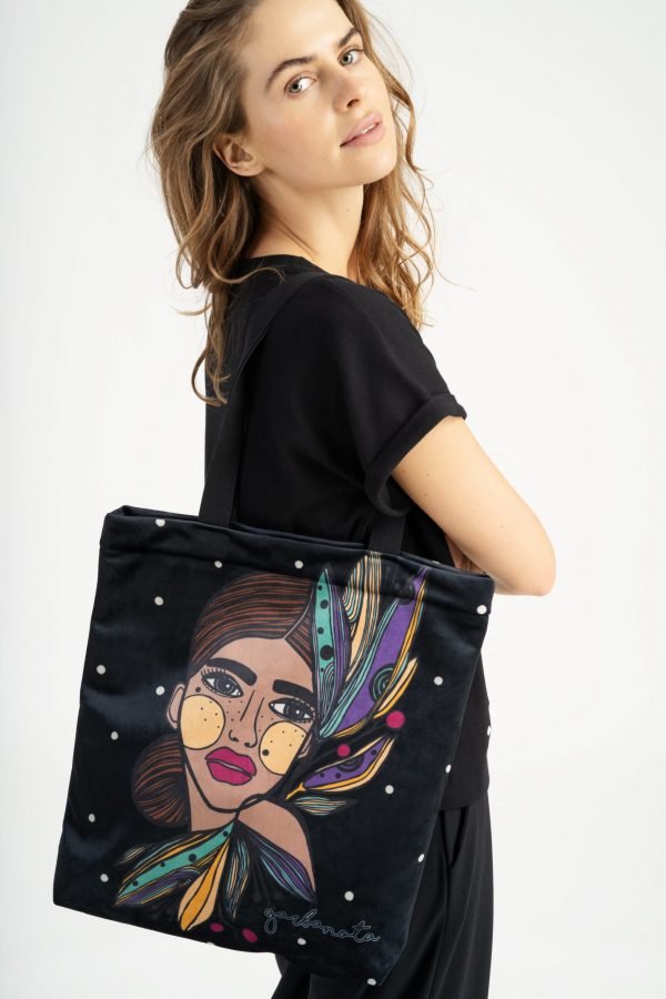 2. Woman wearing Garbanota HANDBAG LILY - COLORED with unique graphic design, shown in studio setting