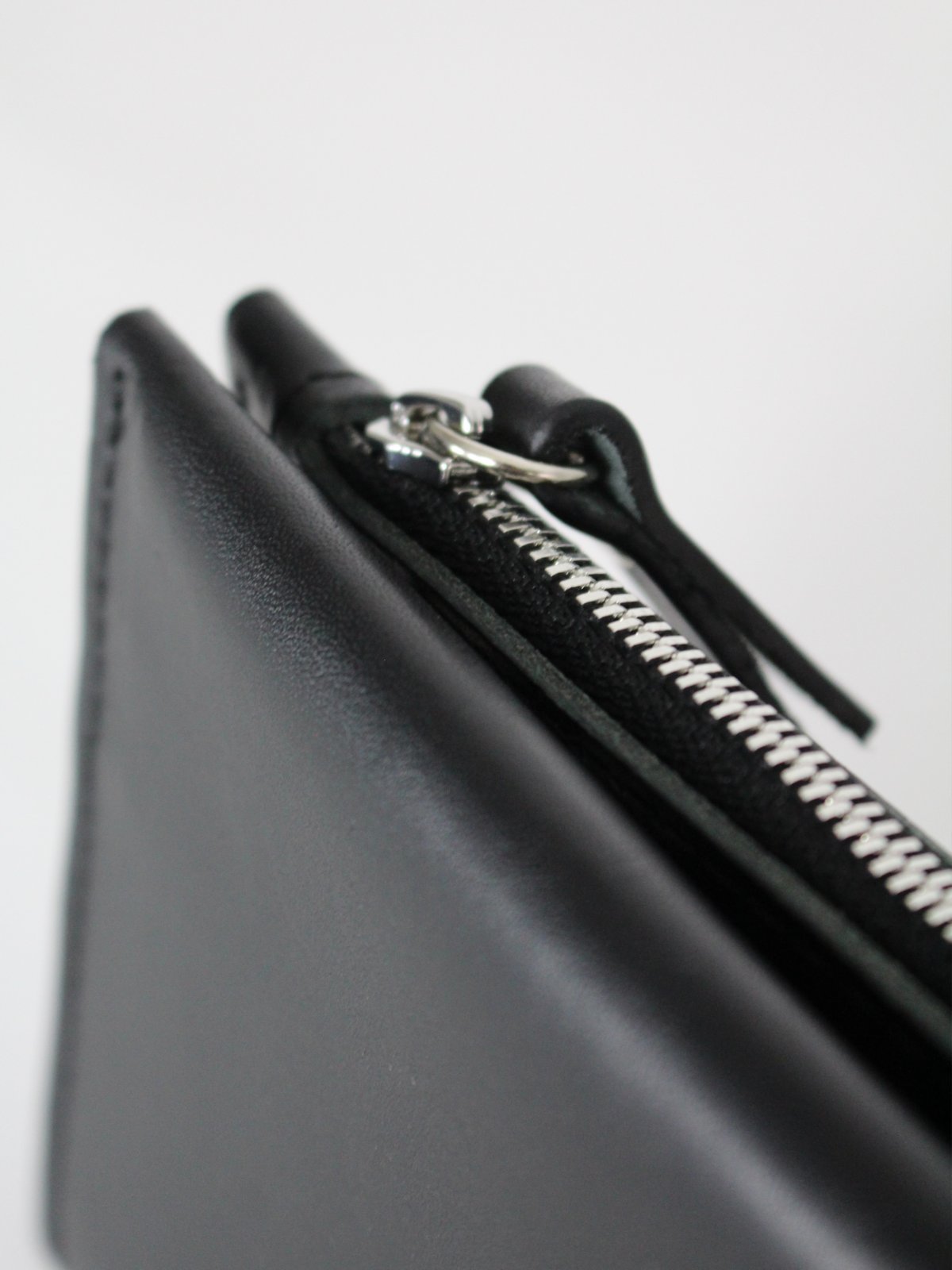 3. Close-up of black Lava flow Classic Leather Wallet TAAL, highlighting zipper detail and craftsmanship