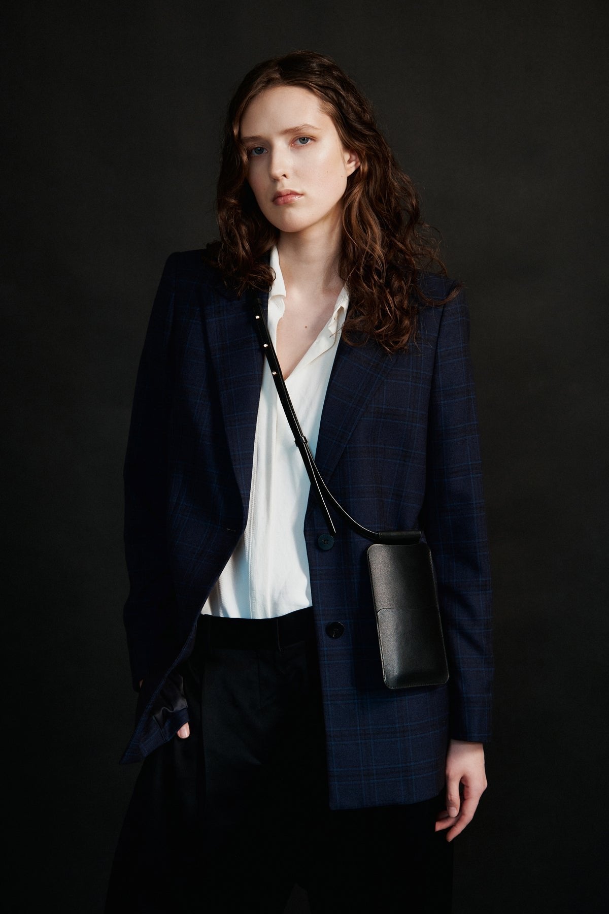 1. Women's black leather phone bag by Tairi Roosve worn crossbody, styled with a navy blazer and white shirt