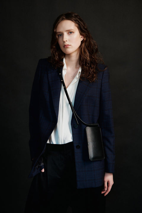 1. Women's black leather phone bag by Tairi Roosve worn crossbody, styled with a navy blazer and white shirt