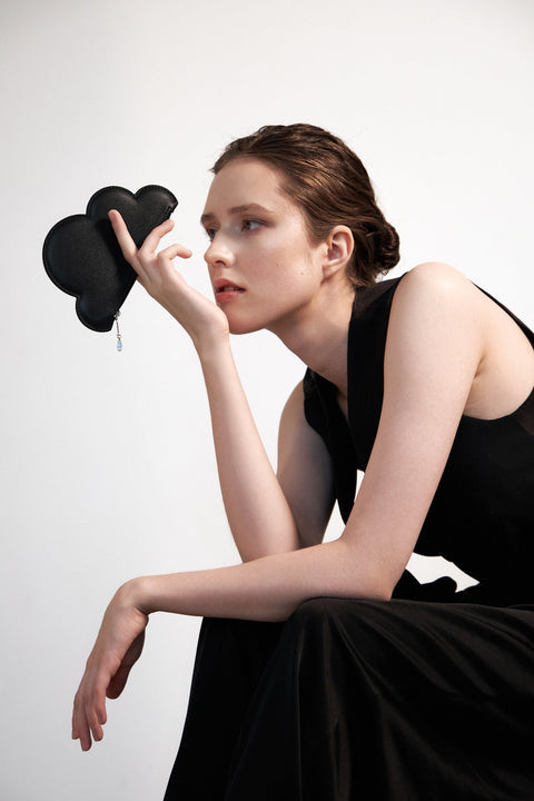 1. Woman holding Tairi Roosve black Leather Cloud Purse with Swarovski crystal zip in studio setting