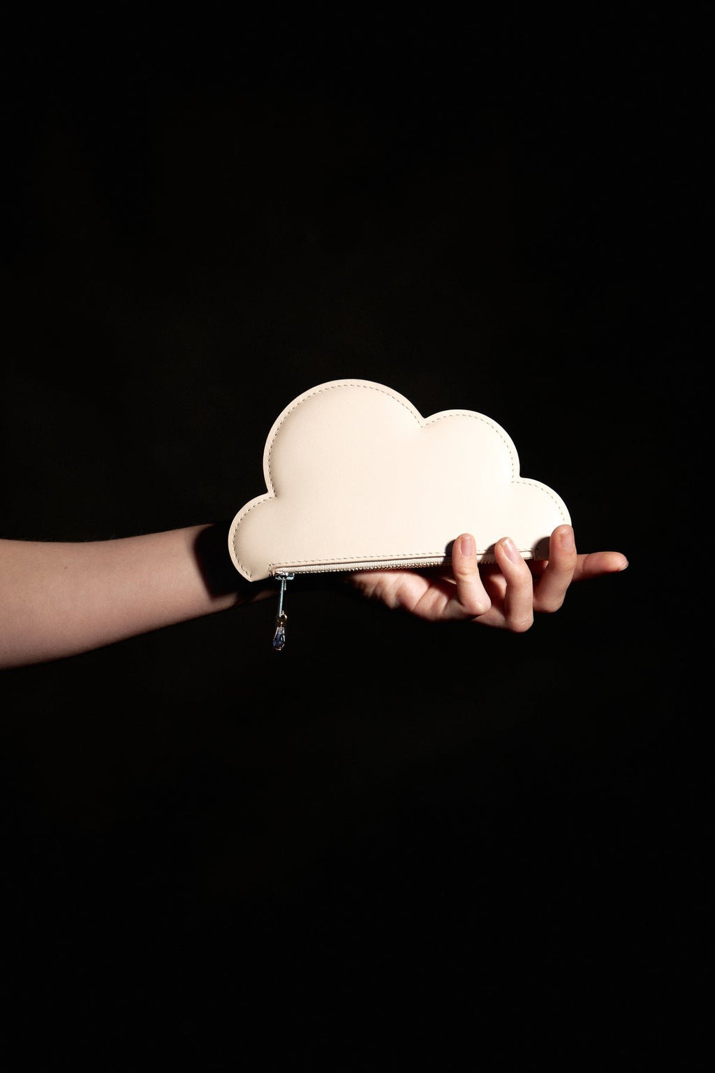 3. Beige leather cloud purse by Tairi Roosve held in hand, showcasing Swarovski crystal zip