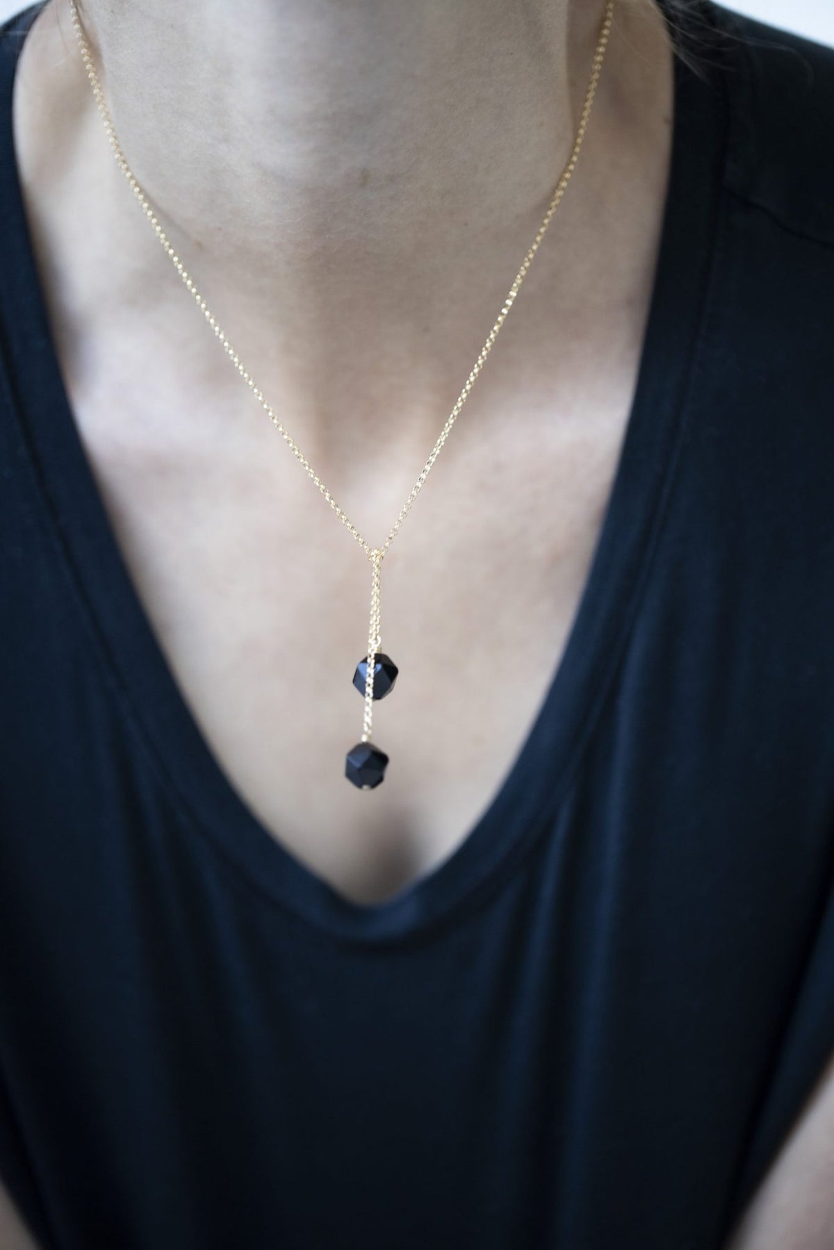 1. Women's Tied To Coco - Onyx necklace by New Vintage by Kriss, featuring faceted onyx stones, worn with a black top