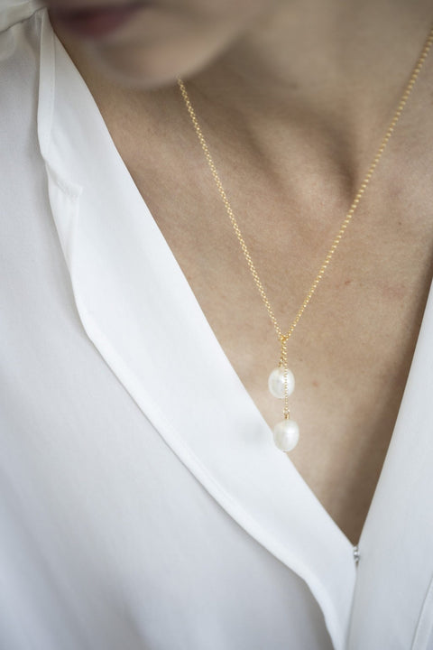 4. Women's TIED TO COCO - Pearl necklace by New Vintage by Kriss, shown with a single pearl drop on a gold-filled chain, worn with a white blouse