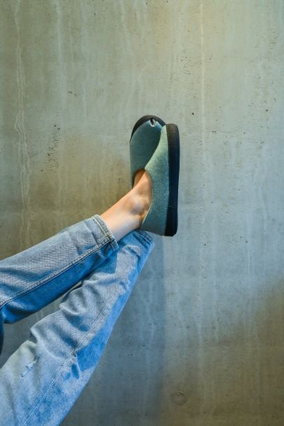 1. Lifestyle image of a person wearing Omaking TOKU Budapest Slippers in mint green, showing comfort and style