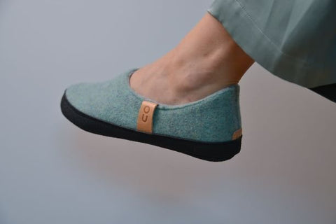 2. Close-up of Omaking TOKU Budapest Slippers in mint green worn by a person, highlighting the natural lambswool felt