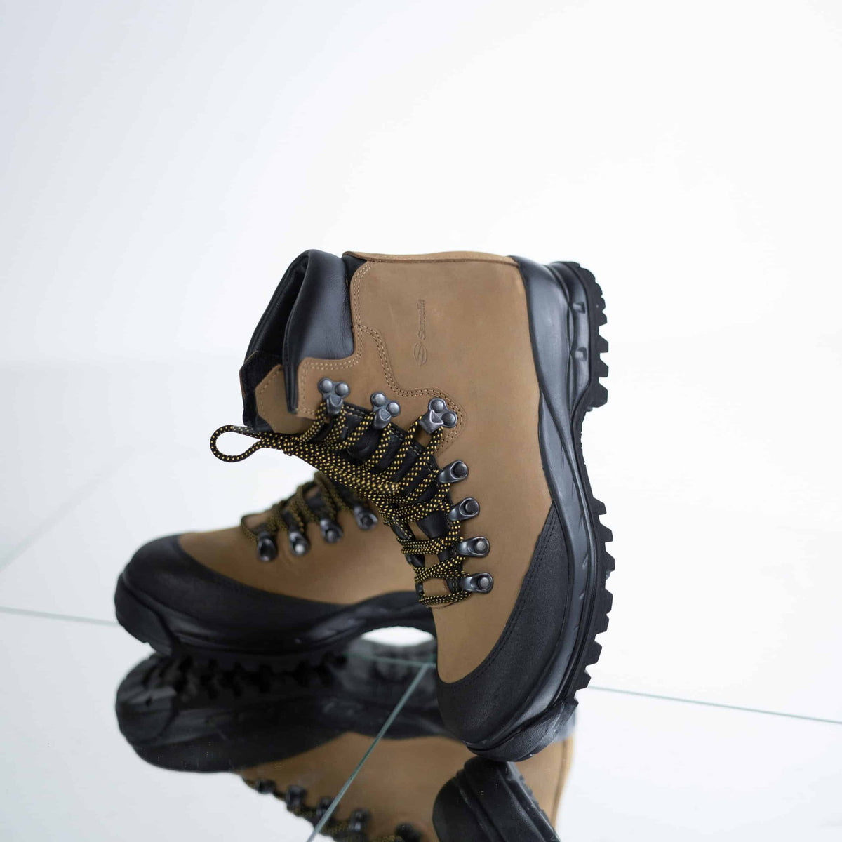 4. Close-up of Samelin 553P Tundra Hiking Boots on reflective surface, emphasizing lace-up design and traction sole