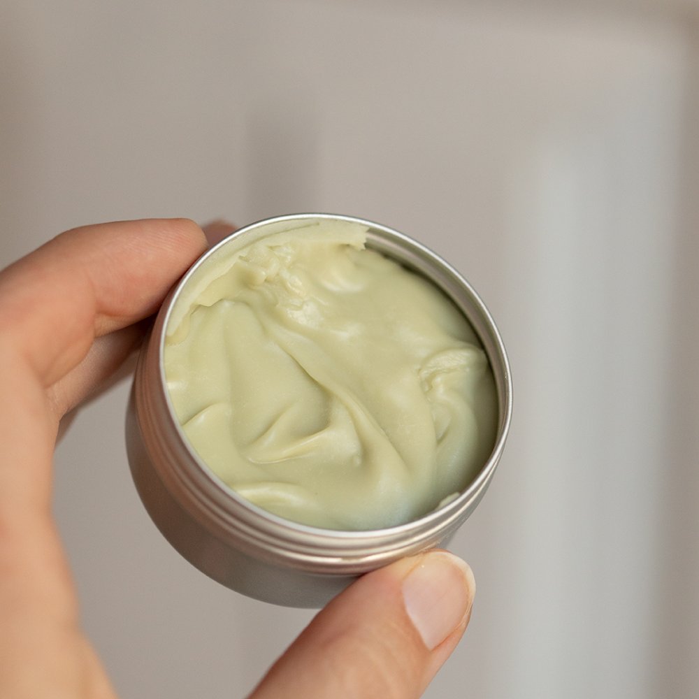 2. Open tin of HOIA homespa cream deodorant showing creamy texture, held in hand
