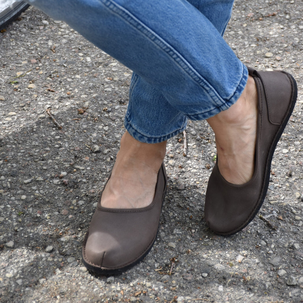 2. Women's Kuutsid Shoes in dark brown by OmaKing, worn by a model with jeans on a concrete surface