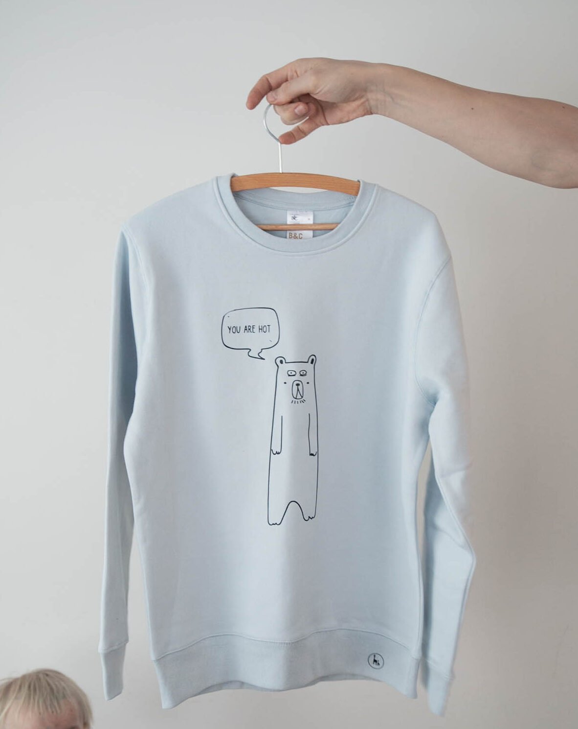 3. Light Blue oversized sweatshirt by Black Giraffe Brand with 'You are hot' bear graphic, displayed on hanger