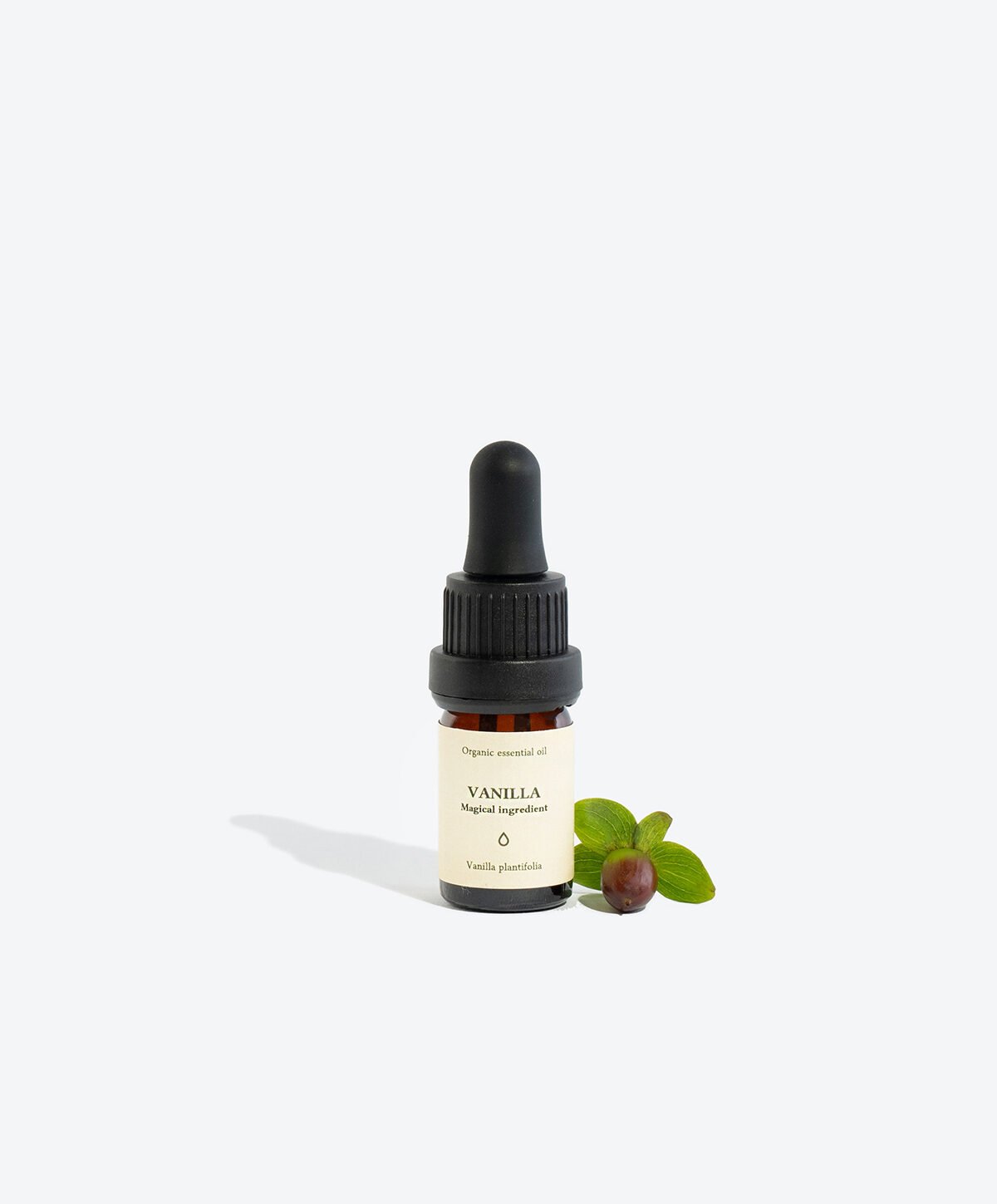 2. Smells Like Spells VANILLA Essential Oil 5 ml glass bottle with pipette, shown with green leaves, studio setting