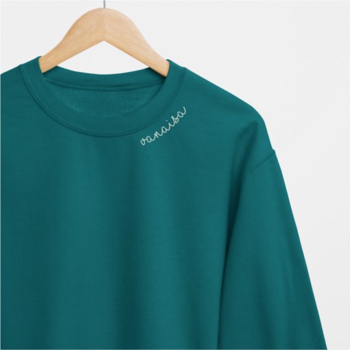 5. Teal Vanaisa sweatshirt by Beebila with embroidered collar, hanging on wooden hanger