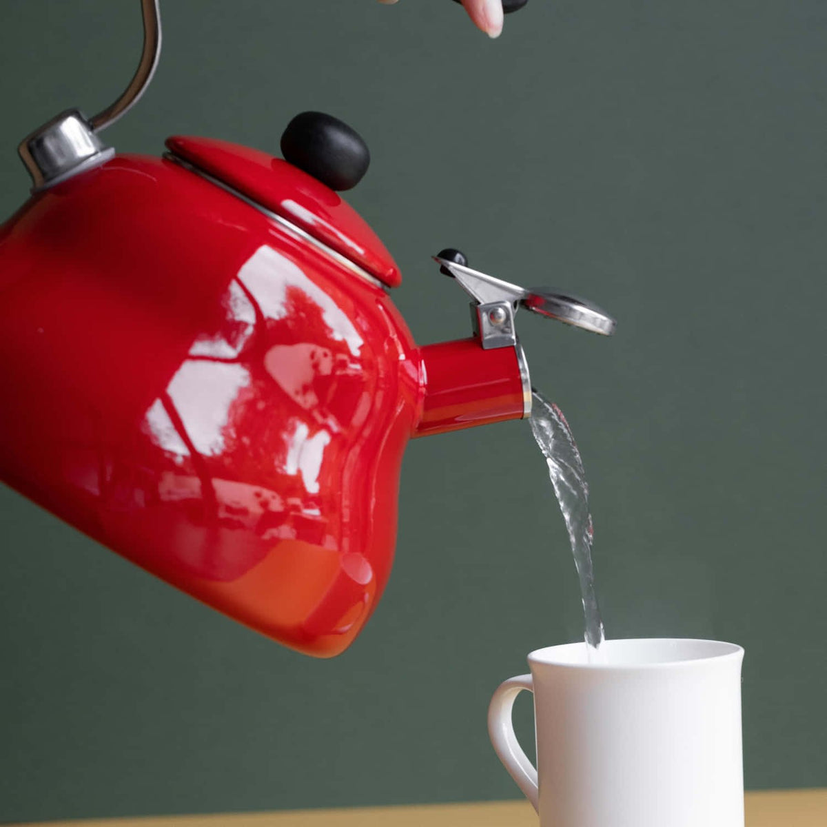 7. Water being poured from red La Cafetière kettle into white mug