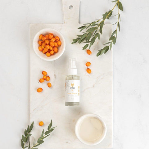 5. Vegan Fox Face Serum with Hyaluronic Acid, 30 ml, flat lay with sea buckthorn and leaves on marble board