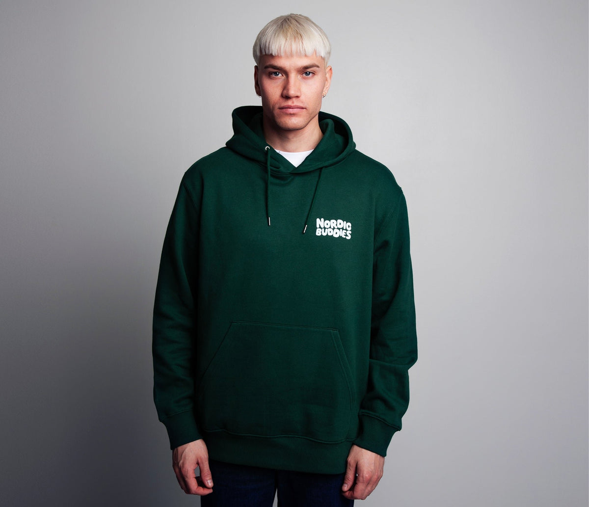 4. Unisex green Moomin hoodie worn by male model, highlighting front Nordic Buddies logo in studio