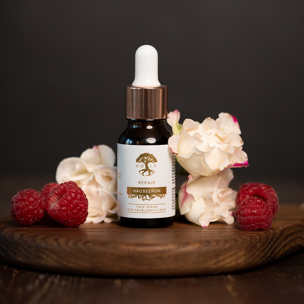 1. HOIA homespa Face Serum REPAIR for problematic skin, surrounded by raspberries and white flowers, lifestyle setting